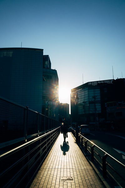 During the day, people walking on the sidewalk near the tall building
